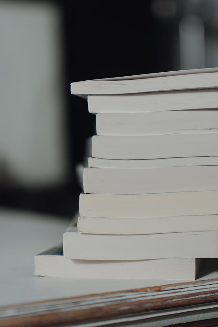 services-01 Close-up of stacked books with focus on spines, offering copy space and a minimalist appeal.